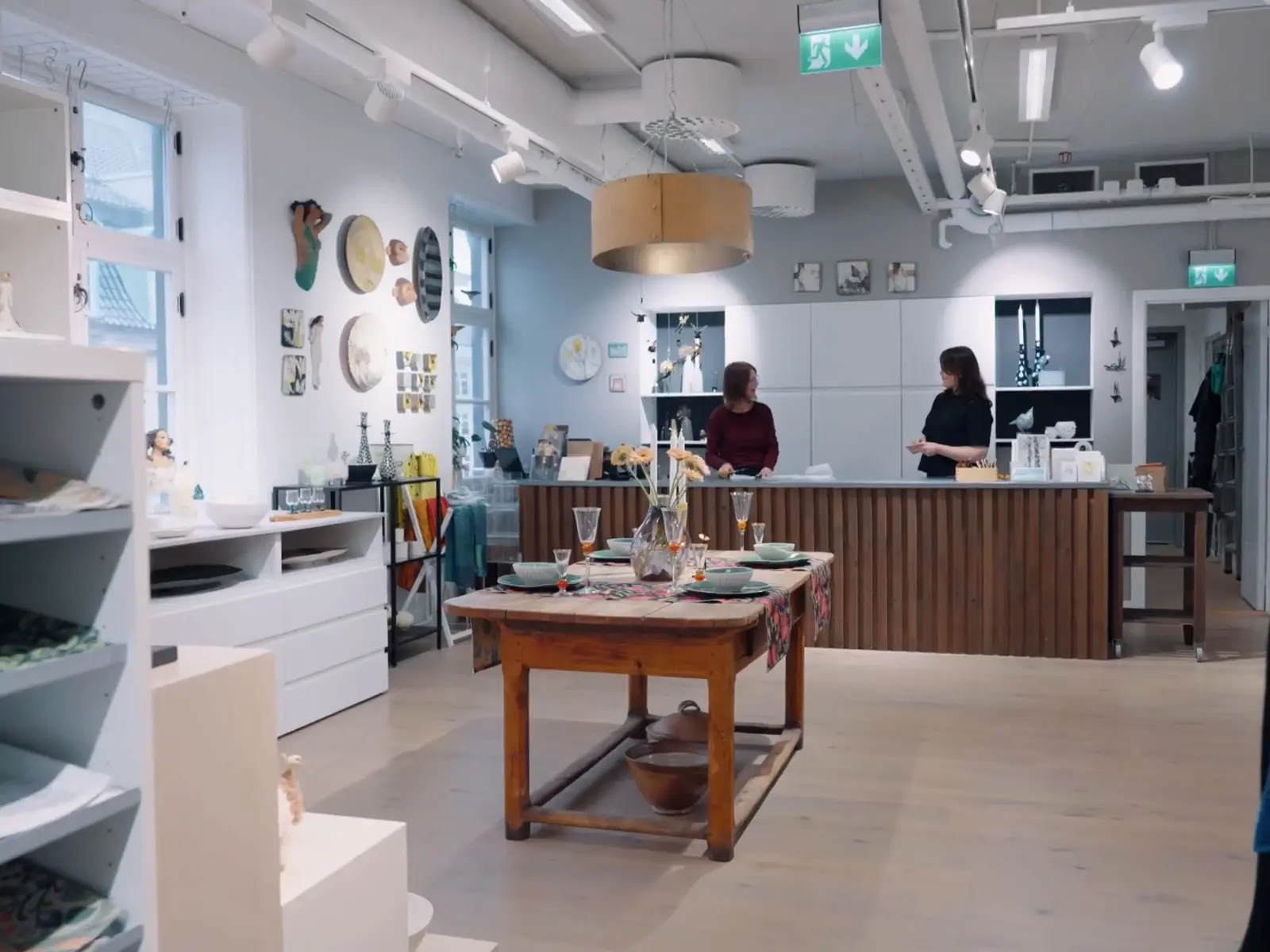 Lyse hyller med keramikk og glass inne i butikken på Galleriet